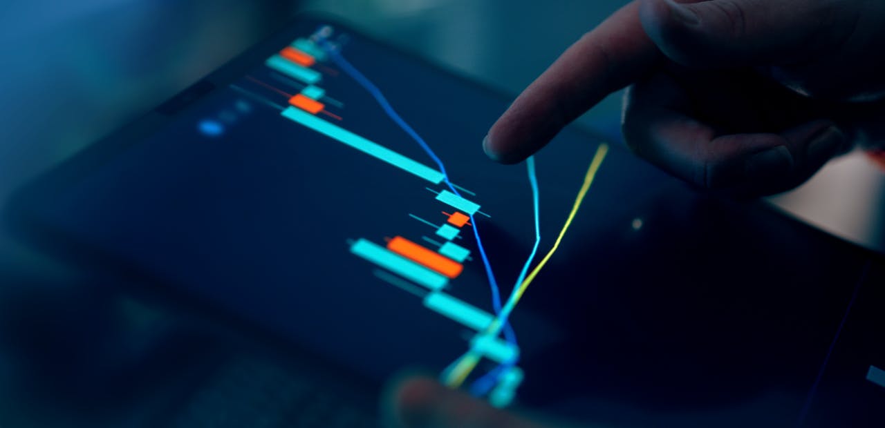 Close-up of a finger interacting with a digital chart on a tablet, depicting financial data and analysis.